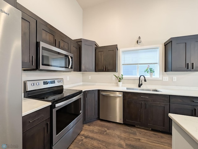 2715 11th St W, West Fargo, ND 58078 - kitchen with appliances with stainless steel finishes, light countertops, dark wood-style floors, dark brown cabinetry, and a high ceiling