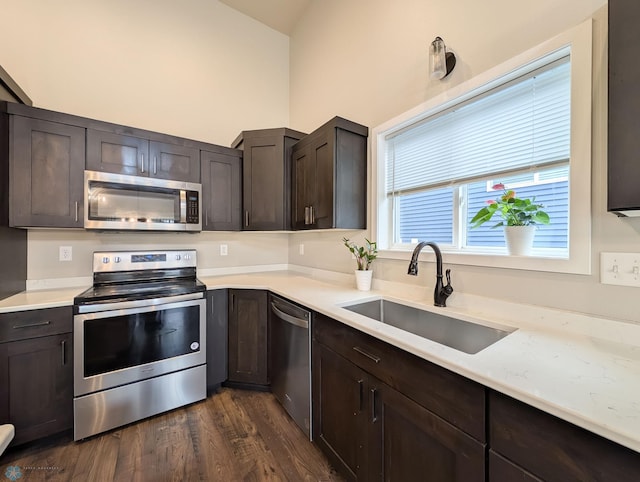 2715 11th St W, West Fargo, ND 58078 - kitchen with appliances with stainless steel finishes, dark wood-style flooring, dark brown cabinetry, light countertops, and lofted ceiling