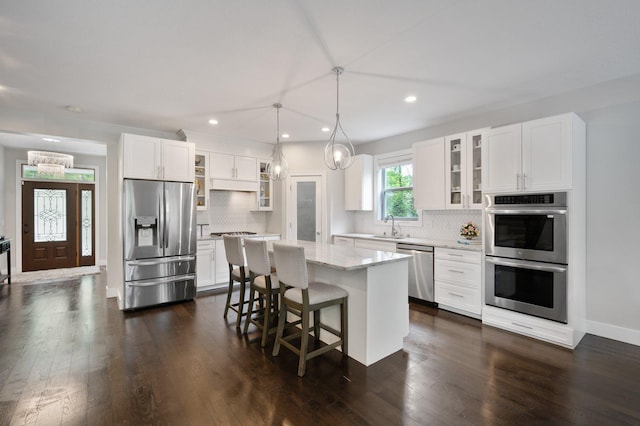 12601 Ridgemount Ave W, Minnetonka, MN 55305 - kitchen with appliances with stainless steel finishes, a kitchen island, backsplash, recessed lighting, and a chandelier