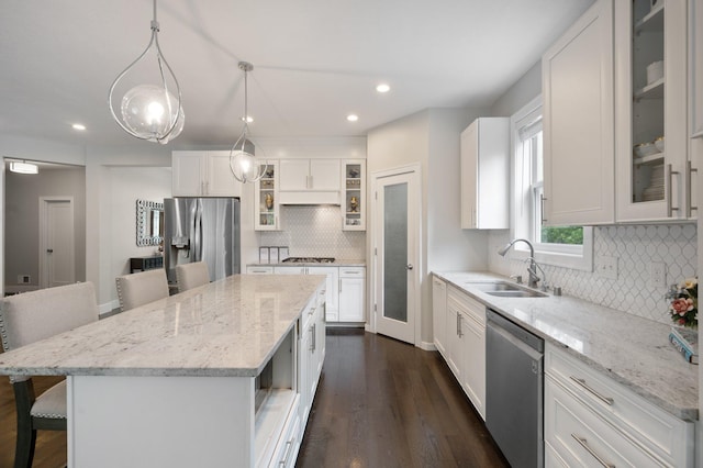 12601 Ridgemount Ave W, Minnetonka, MN 55305 - kitchen with stainless steel appliances, a sink, dark wood-type flooring, backsplash, and a breakfast bar area