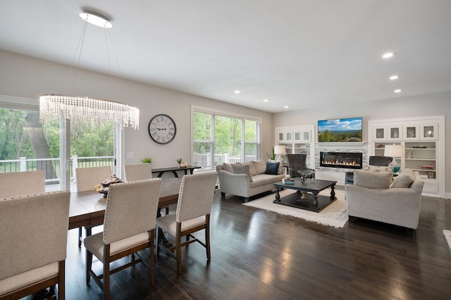12601 Ridgemount Ave W, Minnetonka, MN 55305 - dining area with a glass covered fireplace, dark wood-type flooring, a chandelier, and recessed lighting