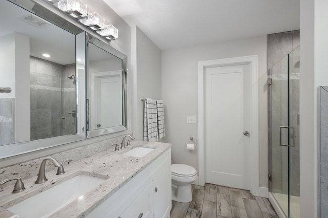 12601 Ridgemount Ave W, Minnetonka, MN 55305 - full bathroom with a stall shower, double vanity, toilet, and wood finished floors