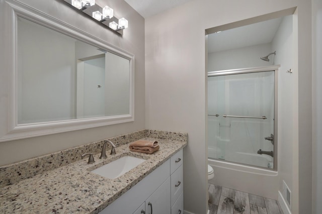 12601 Ridgemount Ave W, Minnetonka, MN 55305 - bathroom with wood finished floors, vanity, toilet, and shower / bath combination with glass door