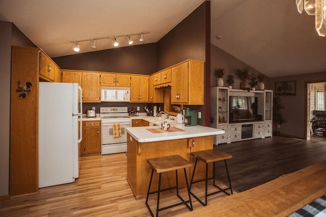 2501 Woodridge Ln, Brainerd, MN 56401 - kitchen featuring white appliances, a peninsula, a sink, light wood-style flooring, and light countertops