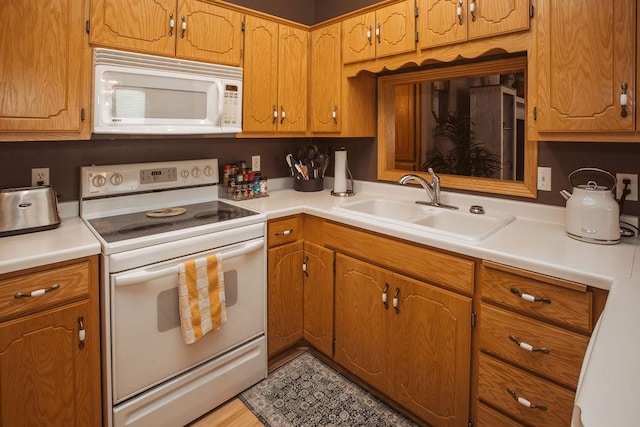 2501 Woodridge Ln, Brainerd, MN 56401 - kitchen featuring white appliances, a sink, light countertops, and brown cabinets