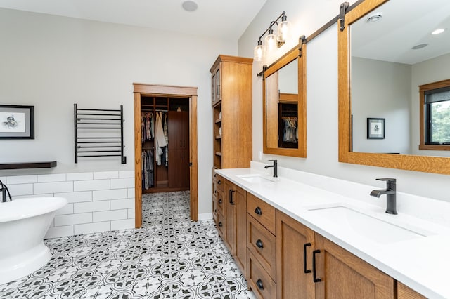 918 Hidden Meadow Ln, Lake City, MN 55041 - full bath featuring double vanity, a soaking tub, a walk in closet, and tile patterned flooring