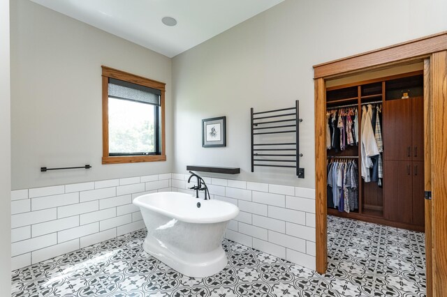 918 Hidden Meadow Ln, Lake City, MN 55041 - full bath featuring tile walls, a freestanding tub, radiator, a wainscoted wall, and tile patterned flooring