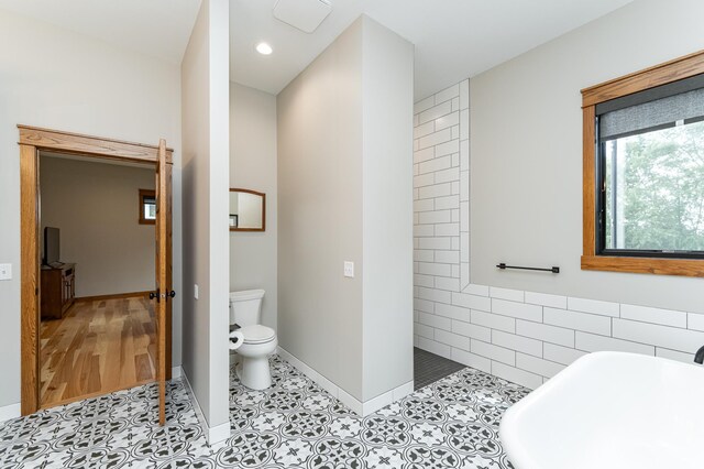 918 Hidden Meadow Ln, Lake City, MN 55041 - full bath featuring a soaking tub, walk in shower, toilet, tile patterned flooring, and tile walls