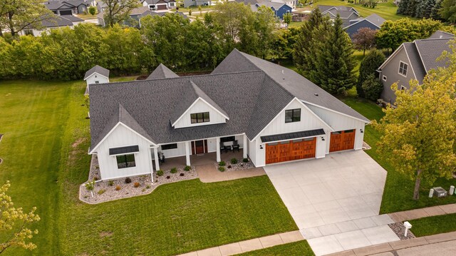 918 Hidden Meadow Ln, Lake City, MN 55041 - view of front of property with board and batten siding, roof with shingles, a porch, concrete driveway, and a front yard