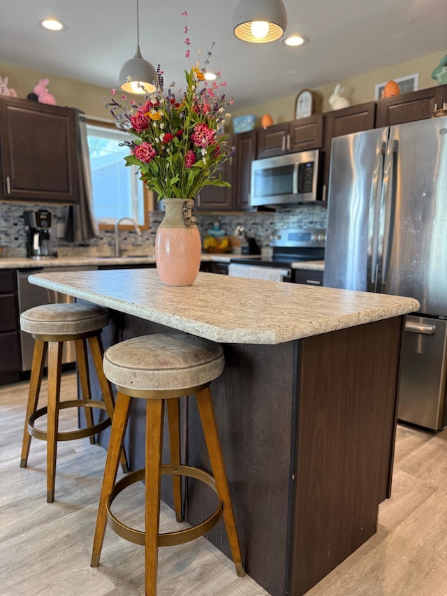 2014 Nelson Dr, Thief River Falls, MN 56701 - kitchen with stainless steel appliances, dark brown cabinets, tasteful backsplash, light countertops, and recessed lighting
