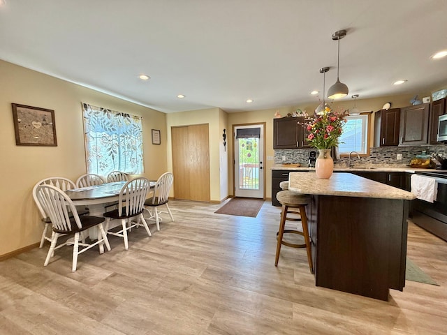 2014 Nelson Dr, Thief River Falls, MN 56701 - kitchen featuring appliances with stainless steel finishes, dark brown cabinets, light countertops, decorative backsplash, and recessed lighting