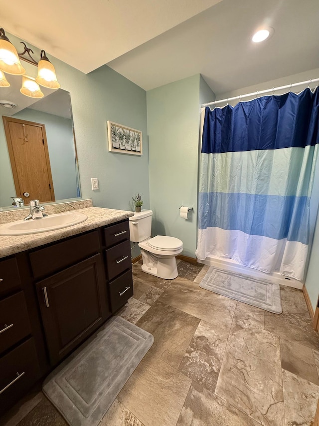 2014 Nelson Dr, Thief River Falls, MN 56701 - full bathroom with toilet, vanity, stone finish floors, and baseboards