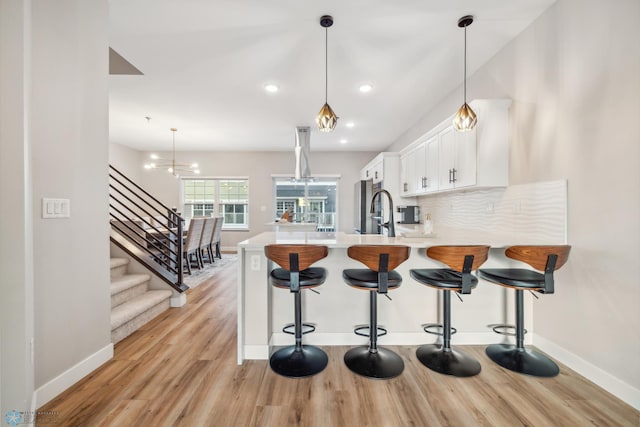 5837 41st St S, Fargo, ND 58104 - kitchen with light countertops, light wood-type flooring, white cabinetry, baseboards, and recessed lighting