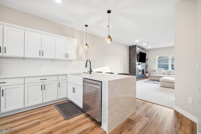 5837 41st St S, Fargo, ND 58104 - kitchen with stainless steel dishwasher, a peninsula, white cabinets, light wood-style floors, and backsplash