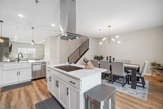 5837 41st St S, Fargo, ND 58104 - kitchen featuring stainless steel dishwasher, island range hood, black electric cooktop, light wood finished floors, and white cabinets