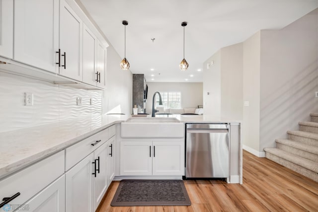 5837 41st St S, Fargo, ND 58104 - kitchen featuring stainless steel dishwasher, a peninsula, light wood finished floors, a sink, and white cabinetry