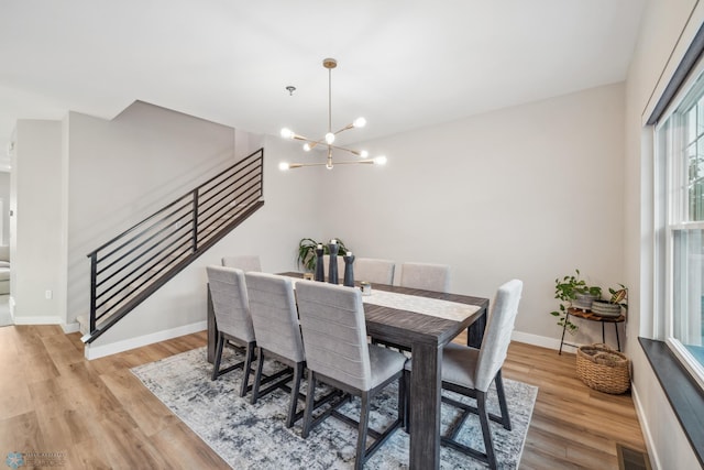 5837 41st St S, Fargo, ND 58104 - dining room featuring stairway, a chandelier, light wood-style floors, and baseboards