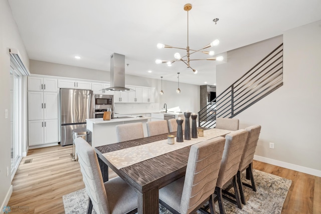 5837 41st St S, Fargo, ND 58104 - dining room featuring a chandelier, recessed lighting, light wood-style floors, baseboards, and stairway