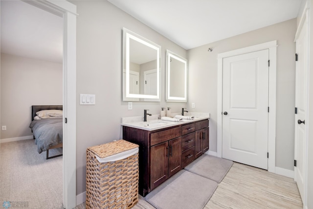 5837 41st St S, Fargo, ND 58104 - full bathroom with double vanity, baseboards, ensuite bath, and wood finished floors