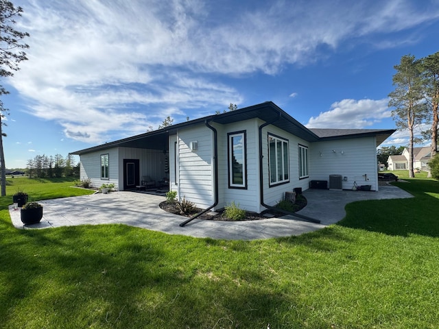 807 Whitetail Ln, Detroit Lakes, MN 56501 - rear view of property with a patio area, a lawn, and central AC