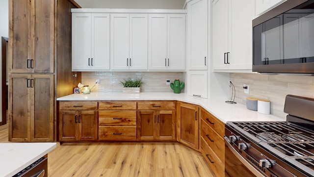 807 Whitetail Ln, Detroit Lakes, MN 56501 - kitchen featuring stainless steel appliances, light wood finished floors, backsplash, and light countertops