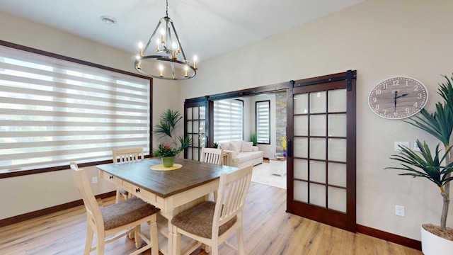 807 Whitetail Ln, Detroit Lakes, MN 56501 - dining area with a chandelier, light wood-type flooring, and baseboards