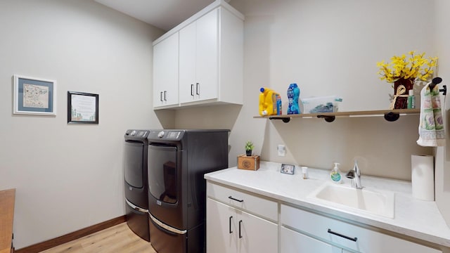 807 Whitetail Ln, Detroit Lakes, MN 56501 - laundry room featuring separate washer and dryer, cabinet space, light wood-style floors, and baseboards