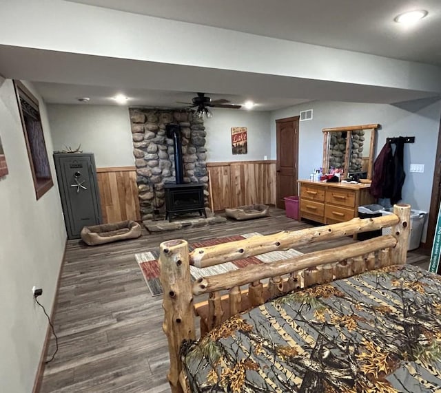 46824 Foss Rd, Osage, MN 56570 - bedroom featuring a wood stove, a wainscoted wall, wood finished floors, and wood walls