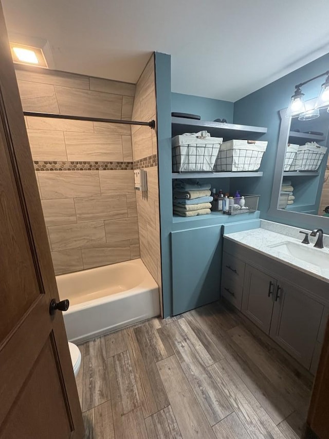 46824 Foss Rd, Osage, MN 56570 - full bathroom featuring toilet, vanity,  shower combination, and wood finished floors