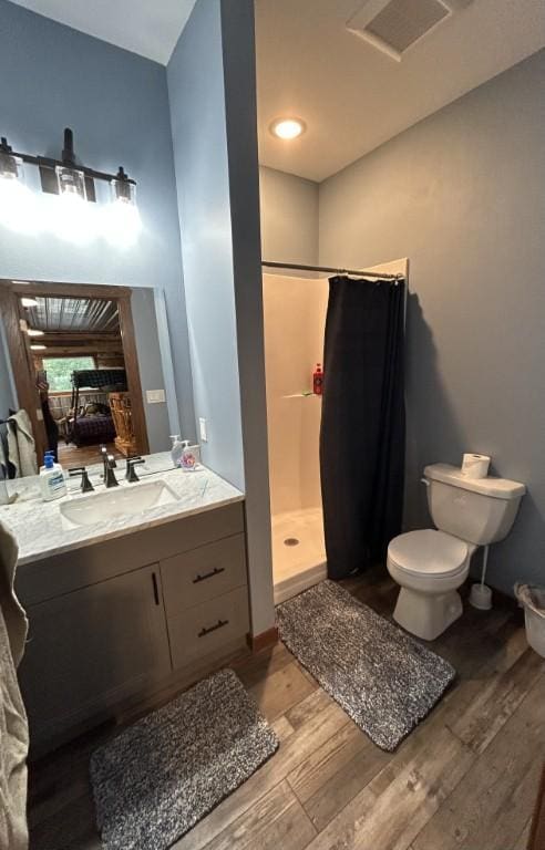 46824 Foss Rd, Osage, MN 56570 - bathroom featuring wood finished floors, a shower stall, toilet, vanity, and baseboards