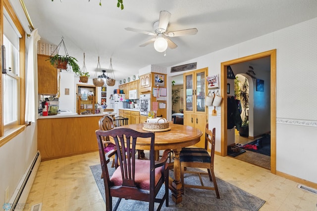 1013 15 1/2 St N, Moorhead, MN 56560 - dining room featuring light flooring, a baseboard heating unit, ceiling fan, wallpapered walls, and baseboards