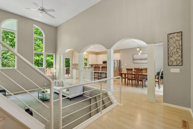 6609 Red Birch Ct, Lino Lakes, MN 55014 - living area with high vaulted ceiling, a ceiling fan, light wood-type flooring, arched walkways, and baseboards