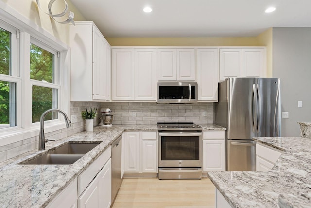 6609 Red Birch Ct, Lino Lakes, MN 55014 - kitchen featuring stainless steel appliances, a sink, white cabinetry, recessed lighting, and light wood finished floors