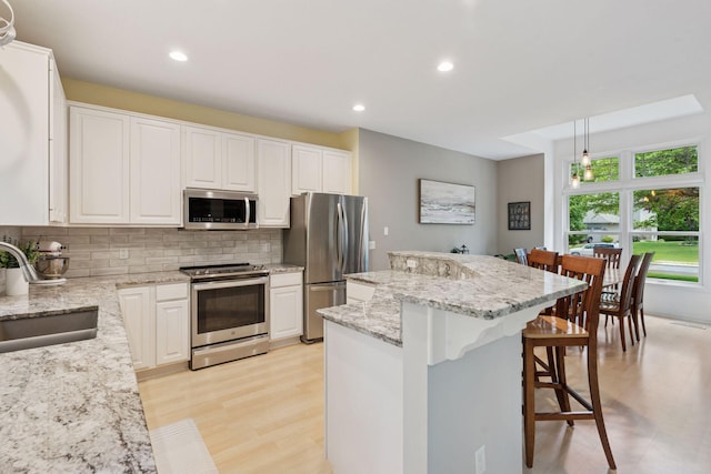 6609 Red Birch Ct, Lino Lakes, MN 55014 - kitchen featuring stainless steel appliances, a sink, light wood-style floors, a kitchen island, and recessed lighting