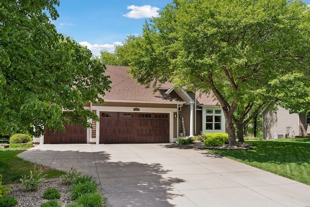 6609 Red Birch Ct, Lino Lakes, MN 55014 - view of property hidden behind natural elements with an attached garage, driveway, a front yard, and a shingled roof