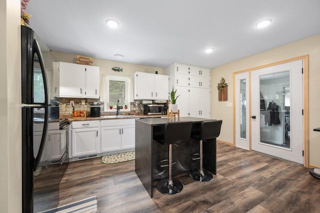 3108 4th Ave, Grand Rapids, MN 55744 - kitchen featuring stainless steel microwave, white cabinets, dark wood-style floors, a sink, and a kitchen island
