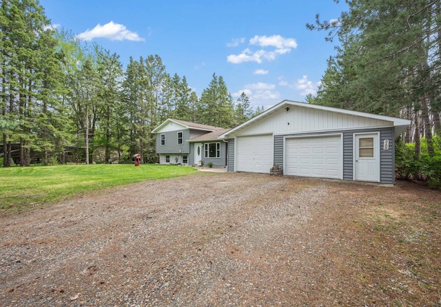 3108 4th Ave, Grand Rapids, MN 55744 - tri-level home with dirt driveway, a garage, and a front lawn
