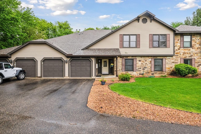 10726 Toledo Ct, Bloomington, MN 55437 - view of front of house with a garage, roof with shingles, asphalt driveway, stone siding, and a front lawn