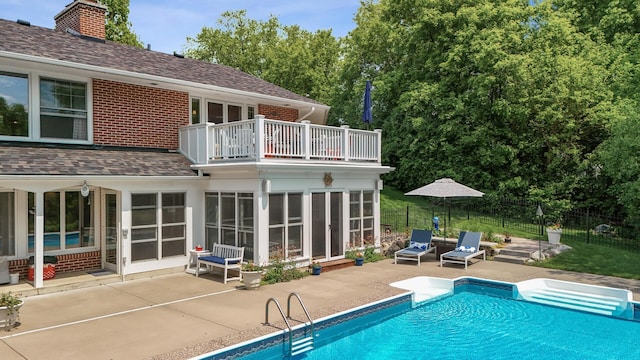 6413 Mendelssohn Ln, Edina, MN 55343 - back of property featuring a balcony, a patio, a chimney, brick siding, and roof with shingles