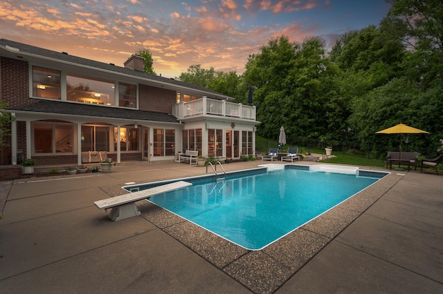 6413 Mendelssohn Ln, Edina, MN 55343 - pool at dusk featuring a patio, an outdoor pool, and a diving board