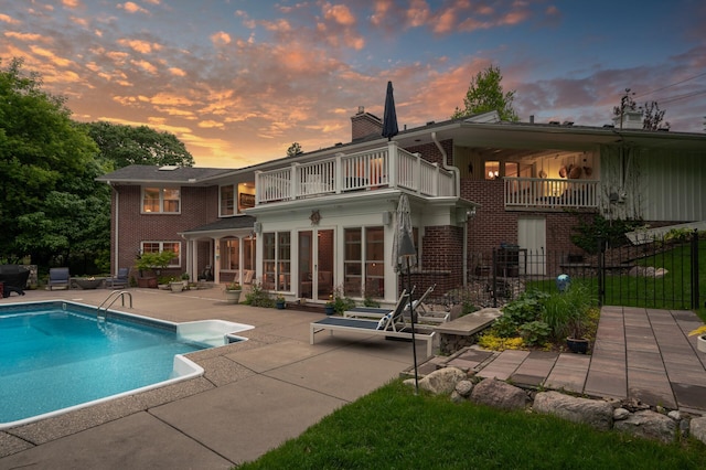 6413 Mendelssohn Ln, Edina, MN 55343 - back of house with a balcony, a patio, brick siding, and a chimney