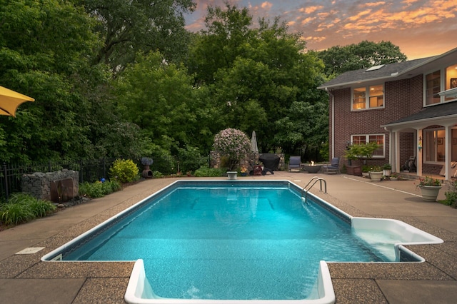 6413 Mendelssohn Ln, Edina, MN 55343 - pool at dusk featuring a patio area, an outdoor pool, and a diving board