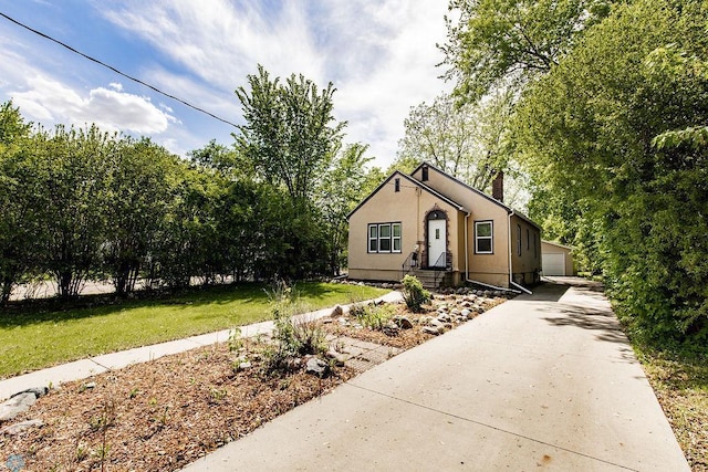 1342 10th St N, Fargo, ND 58102 - bungalow featuring a chimney, an outdoor structure, a front lawn, and stucco siding