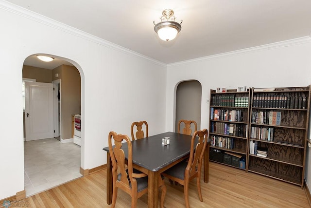 1342 10th St N, Fargo, ND 58102 - dining area with arched walkways, ornamental molding, light wood-style flooring, and baseboards