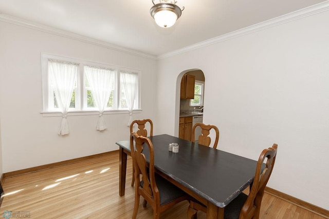 1342 10th St N, Fargo, ND 58102 - dining area with arched walkways, light wood-style floors, baseboards, and ornamental molding