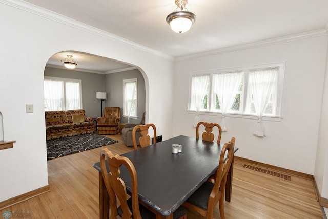 1342 10th St N, Fargo, ND 58102 - dining space with arched walkways, baseboards, light wood finished floors, and ornamental molding