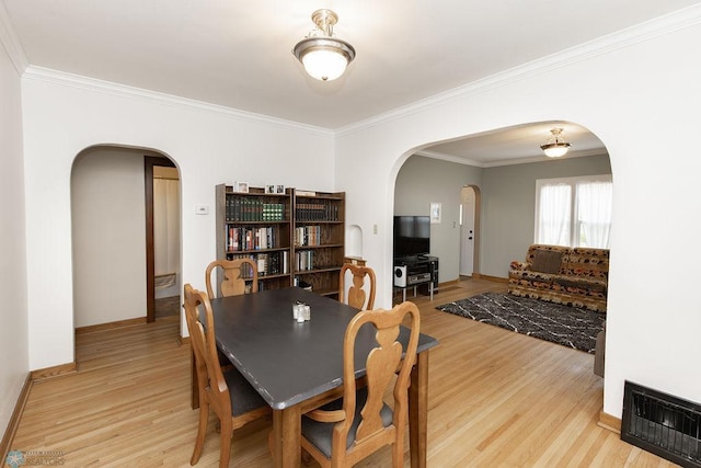 1342 10th St N, Fargo, ND 58102 - dining space with arched walkways, light wood finished floors, ornamental molding, and baseboards