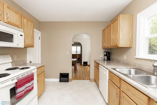 1342 10th St N, Fargo, ND 58102 - kitchen with white appliances, a sink, arched walkways, and light countertops