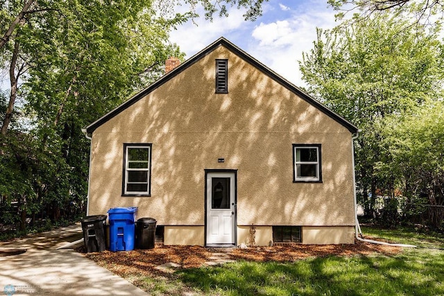 1342 10th St N, Fargo, ND 58102 - back of house featuring a chimney and stucco siding