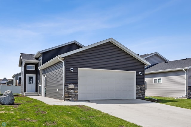 6718 69th Ave S, Horace, ND 58047 - view of front of house with stone siding, an attached garage, and concrete driveway